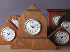 three wooden clocks sitting next to each other on a table