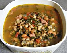 a white bowl filled with beans and greens