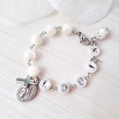 This stunning Baptism bracelet is a truly divine piece that combines elegance and spiritual significance. Crafted with natural mother of pearl beads, it features gold plated virgin Mary and cross charms that symbolize protection and faith. The bracelet is personalized with a handcrafted initial letter, adding a unique touch to this meaningful piece. Perfect for commemorating a special occasion or as a thoughtful gift, this bracelet is a beautiful reminder of faith and blessings. *MATCHING ROSARY Pearl Charm Mother Of Pearl Bracelets As Gift, White Spiritual Pearl Bracelet For Gift, Spiritual White Pearl Bracelet Gift, Spiritual White Mother Of Pearl Jewelry, Adjustable Mother Of Pearl Bracelet As Gift, Adjustable Mother Of Pearl Bracelets As Gifts, Adjustable Mother Of Pearl Bracelets For Gifts, Personalized Silver Pearl Bracelet For Birthday, Elegant Personalized Rosary Bracelet As Gift