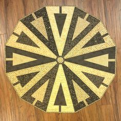 a close up of a black and yellow rug on a wooden floor