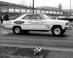 an old black and white photo of a drag car being pulled by a fire hydrant