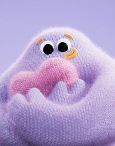 a close up of a stuffed animal with big eyes and a pink heart in its mouth