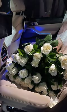 a bouquet of white roses sitting in the back seat of a car