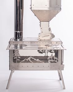 a machine that is sitting on top of a metal stand with mountains in the background