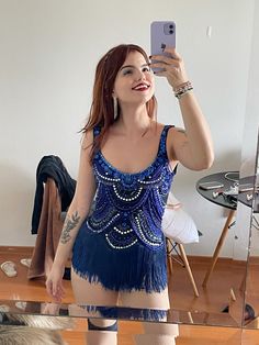 a woman taking a selfie with her cell phone while wearing a blue dress and stockings