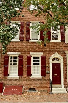 a brick building with red shutters and white trim