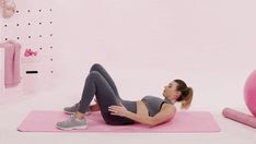 a woman is doing exercises on a pink mat in the room with balls and exercise equipment