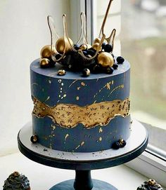 a blue and gold decorated cake sitting on top of a table