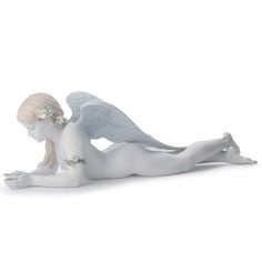 a white figurine laying on the ground with her legs spread out and head down