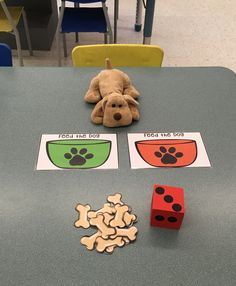 a stuffed dog sitting on top of a table next to some dices and paper