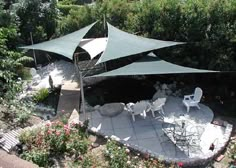 an aerial view of a patio with tables and chairs under a green awning over it