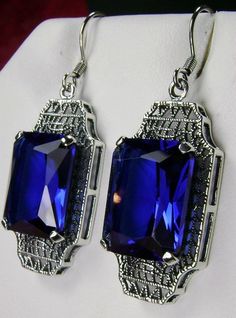 "Simulated Blue Sapphire Earrings Lantern Design#E13 Custom Made Inspired by the Art Deco movement of the early 1900s, these lovely antique reproduction earrings have been crafted in sterling silver. These earrings were refashioned from an antique Art Deco brooch. Each stunning 9 carat simulated blue sapphire gem is 15mm x 12mm. The earrings are 1-3/4\" long and 9/16\" at their widest point. Art Deco style is amazing. The geometric shapes accent the bright facets in the gemstone. These earrings Vintage Sapphire Jewelry For Formal Occasions, Retro Blue Drop Earrings Jewelry, Classic Formal Earrings With Rectangular Stone, Classic Rectangular Party Earrings, Classic Rectangular Pierced Jewelry, Nickel-free Rectangular Earrings For Formal Occasions, Nickel Free Rectangular Earrings For Formal Occasions, Rectangular Blue Earrings For Anniversary, Blue Victorian Earrings For Wedding