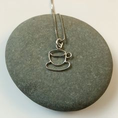 "This hand formed sterling silver pendant is a cup and saucer, perfect for anyone who loved coffee, tea, or cappuccino. This delicate pendant is 5/8\" tall including the bail and just over 1/2\" wide. The pendant is on a .85 mm wide sterling silver box chain. Please select the length chain you would like. The necklace will be shipped in a decorative cardboard jewelry box filled with an anti tarnish cotton. Sterling silver is a metal that can tarnish, storing it in the box in which it is shipped