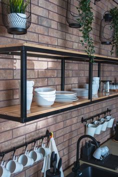 the shelves are filled with dishes and cups on them, along with hanging planters