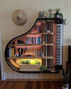 a piano shelf with books and plants on it