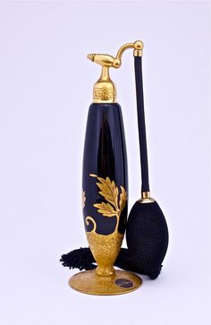 a black and gold vase sitting next to a brush