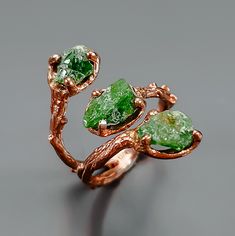 This ring features three amazing raw emerald gemstones in bright green color. Handcrafted with great details in rose gold colors. Charming, isn't it? ♥ The design can be made with gemstones of your choosing ♥ Each order will be gift wrapped beautifully ♥ QUALITY: Each item is stamped according to US regulations.  ------   *DIMENSIONS*  ------ ♥ Ring Size: 7.5 US as you see it on the picture. It could be easily adjustable according to your finger, just squeeze it a little or open.  Main Metal: 92 Green Three Stone Ring Jewelry, Green Raw Stone Jewelry For May Birthstone, Nature-inspired Green Jewelry With Raw Stone, Nature-inspired Green Emerald Ring For Anniversary, Nature-inspired Green Emerald Anniversary Ring, Unique Green Crystal Promise Ring, Unique Green Crystal Ring For Anniversary, Unique Green Jewelry With Raw Stone, Unique Green Crystal Anniversary Ring