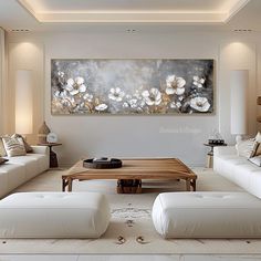 a living room filled with white couches and a coffee table in front of a painting