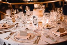 the table is set with silverware and white linens for an elegant wedding reception