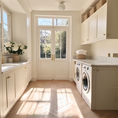 a washer and dryer sitting in a kitchen next to a window with the sun shining through