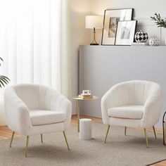 two white chairs sitting next to each other in a living room