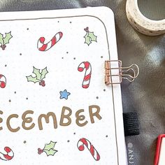 an open notebook with the word december written on it and candy canes around it