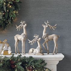 three reindeer figurines sitting on top of a mantle