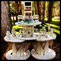 an outdoor table with jars and candles on it