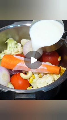 a pot filled with vegetables and milk being poured into it's lid to make a salad