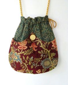 a purse hanging on a wall with a rope attached to the front and side of it