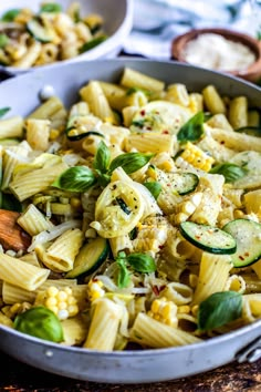 a pan filled with pasta and vegetables on top of a table