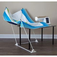 an ironing board sitting on top of a wooden floor next to a computer desk