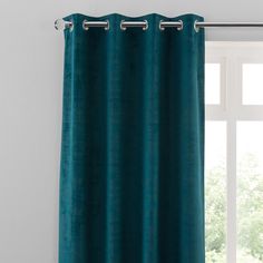 teal curtains with metal grommet rings on the top and bottom, hanging in front of a window