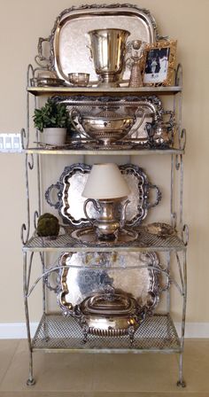 a metal shelf with plates and cups on it