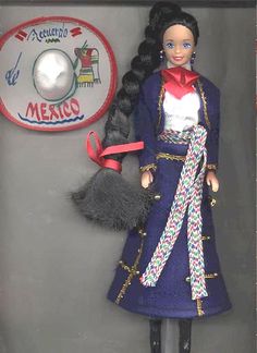 a doll with long black hair wearing a blue coat and red bow tie, standing in front of a sign that says mexico