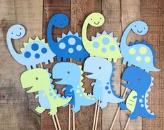 blue and green dinosaur cupcake toppers on sticks with wooden stickers in the shape of dinosaurs