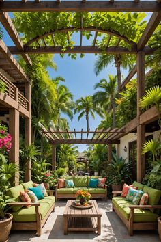 an outdoor seating area with green couches and tropical plants