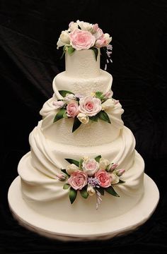 a white wedding cake with pink flowers on top