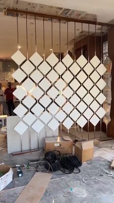 a group of boxes sitting on top of a floor next to a metal cage with lights hanging from it