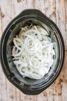 an overhead view of onions in a slow cooker