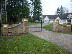 a driveway with a gate and some lights on it