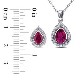 Celebrate the one you love with this classic and elegant pendant and earrings set. Expertly crafted in sleek sterling silver, both the earrings and pendant feature pear-shaped lab-created red ruby center stones. Halo frames of shimmering lab-created white sapphires wrap each ruby in a sparkling embrace. Polished to a brilliant shine, the pendant suspends along an 18.0-inch cable chain that secures with a spring-ring clasp. The post earrings secure comfortably with friction backs. This set arrive Red Lab, Pendant And Earring Set, White Lab, Peoples Jewellers, Elegant Pendant, Sapphire Pendant, Red Ruby, Stud Earrings Set, White Sapphire