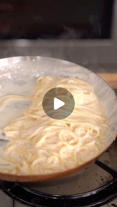 a bowl filled with noodles sitting on top of a stove