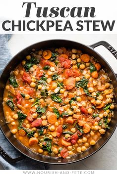 a pan filled with chickpea and spinach stew on top of a blue towel