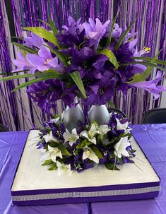 a bouquet of purple flowers on top of a book