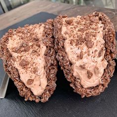 two cookies with chocolate frosting and sprinkles sitting on top of a table