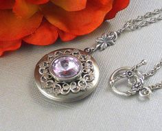 Lavender purple Victorian Steampunk Locket is 30 inches long. Feminine antique silver locket is decorated with Victorian style antique silver floral frame. I have set Swarovski stone in the middle of locket which is set in silver setting. Pendant is hanging from a antique silver leafy rosary link. Necklace is finished with antique silver chain and antique silver floral toggle clasp. Locket is 32mm in size. It opens and has room for two photos inside. Please note: I DO NOT DO ENGRAVING OR INSERT Vintage Lavender Jewelry For Wedding, Vintage Lavender Wedding Jewelry, Vintage Lavender Round Jewelry, Vintage Lavender Jewelry For Gifts, Vintage Lavender Jewelry, Swarovski Stones, Victorian Steampunk, Silver Lockets, Victorian Fashion