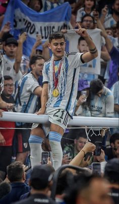 a man standing on top of a metal bar in front of a crowd