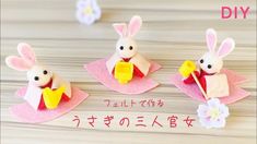 three paper rabbits are sitting on pink napkins