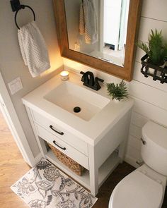 a bathroom with a sink, toilet and mirror on the wall next to it is instagram